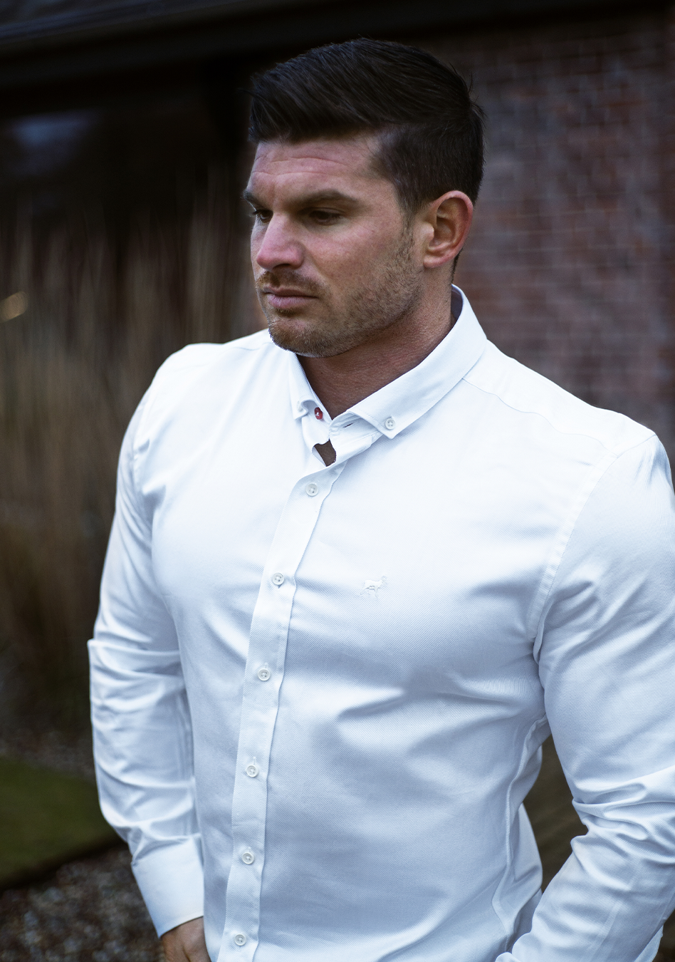 Tom Coleman in Oxcloths White muscle fit shirt on an athletically built model, showcasing the athletic fit design that enhances physique, with stretch fabric for comfort and mobility